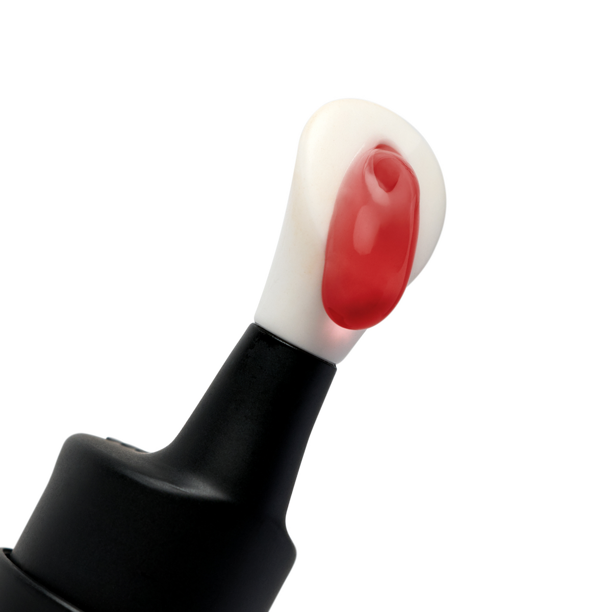 Red and white dual-colored paint drops on the tip of a black squeeze paint bottle, isolated on white background.