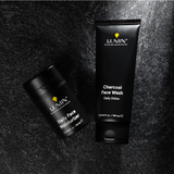 Lumin men's skincare charcoal face wash and daily face moisturizer on textured black surface for daily detox and hydration.