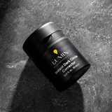 Lumin men's Instant Dark Circle Corrector skincare jar on textured dark stone background, 0.67 fl oz packaging.