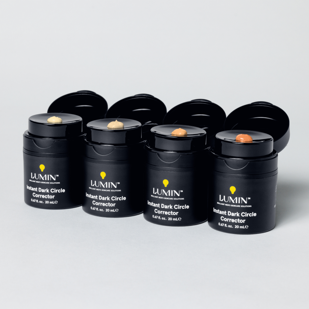 Lumin men's Instant Dark Circle Corrector jars in various shades of concealer cream for under-eye skincare.