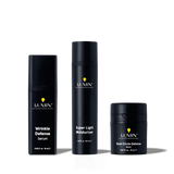 Lumin men's skincare set with Wrinkle Defense Serum, Super Light Moisturizer, and Dark Circle Defense Balm in black bottles.