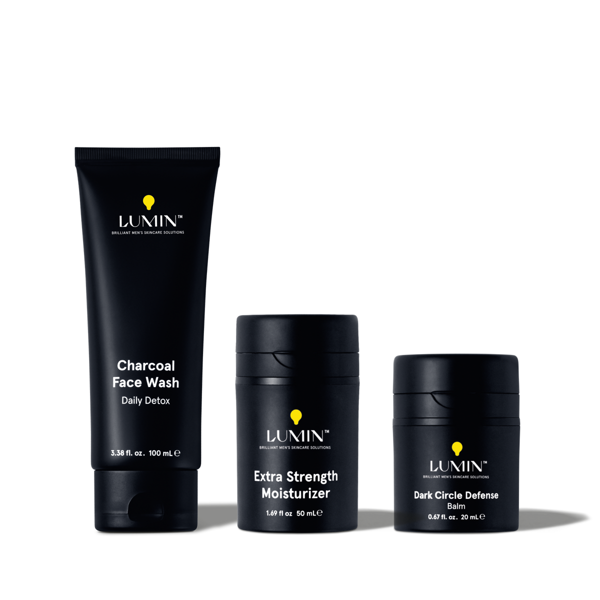 Lumin men's skincare set with Charcoal Face Wash, Extra Strength Moisturizer, and Dark Circle Defense Balm in black packaging.