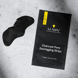 Lumin charcoal pore declogging single-use nose strips for men's skincare on textured concrete background