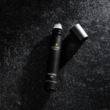 Lumin men's Recovery Oil roller bottle with black cap on textured dark surface, 0.27 fl oz skincare product