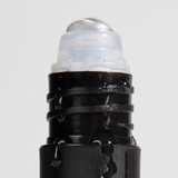 Black roll-on deodorant with water droplets on the applicator, emphasizing freshness and moisture-resistant design.