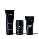 Lumin men's charcoal face wash, daily face moisturizer, and charcoal scrub skincare products in black packaging.