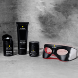 Lumin men's skincare set with daily face moisturizer, charcoal face wash, dark circle defense balm, and LED therapy mask on gray background