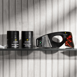 Lumin men's skincare products with Dark Circle Defense Balm, Instant Dark Circle Corrector, and red light therapy eye mask on glass shelf.