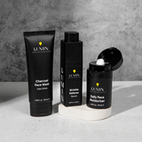 Lumin men's skincare trio: Charcoal Face Wash, Wrinkle Defense Serum, and Daily Face Moisturizer on white surface.